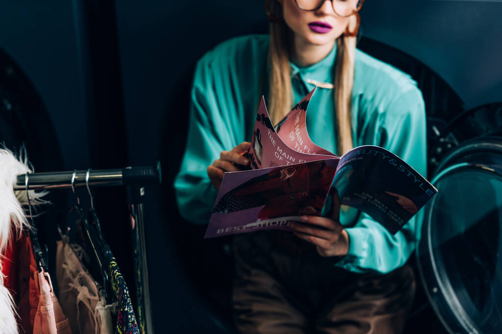 ostříhaný pohled na stylovou ženu držící časopis v prádelně  - Fotografie, Obrázek
