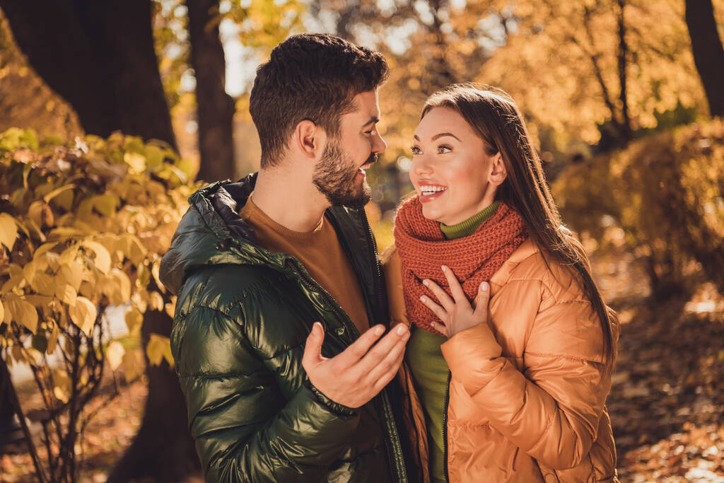 Photo of positive two buddies guy tell his amazed girl news in autumn outdoors september city park wear outerwear - Photo, Image