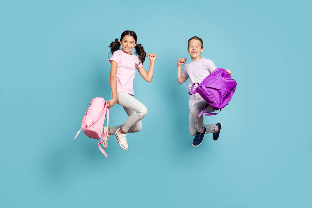 Full length body size view of his he her she nice attractive small cheerful buddy fellow friends friendship jumping having fun rejoicing good mood isolated blue pastel color background - Фото, изображение