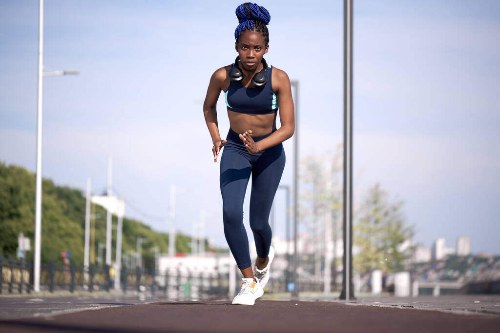 νεαρή μαύρη γυμνάστρια που τρέχει στο στάδιο - Φωτογραφία, εικόνα