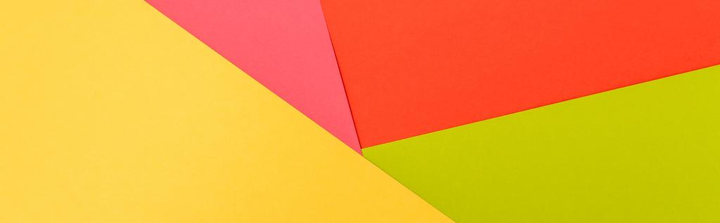 bovenaanzicht van kleurrijke abstracte gele, rode, groene en roze papieren achtergrond, panoramische opname - Foto, afbeelding