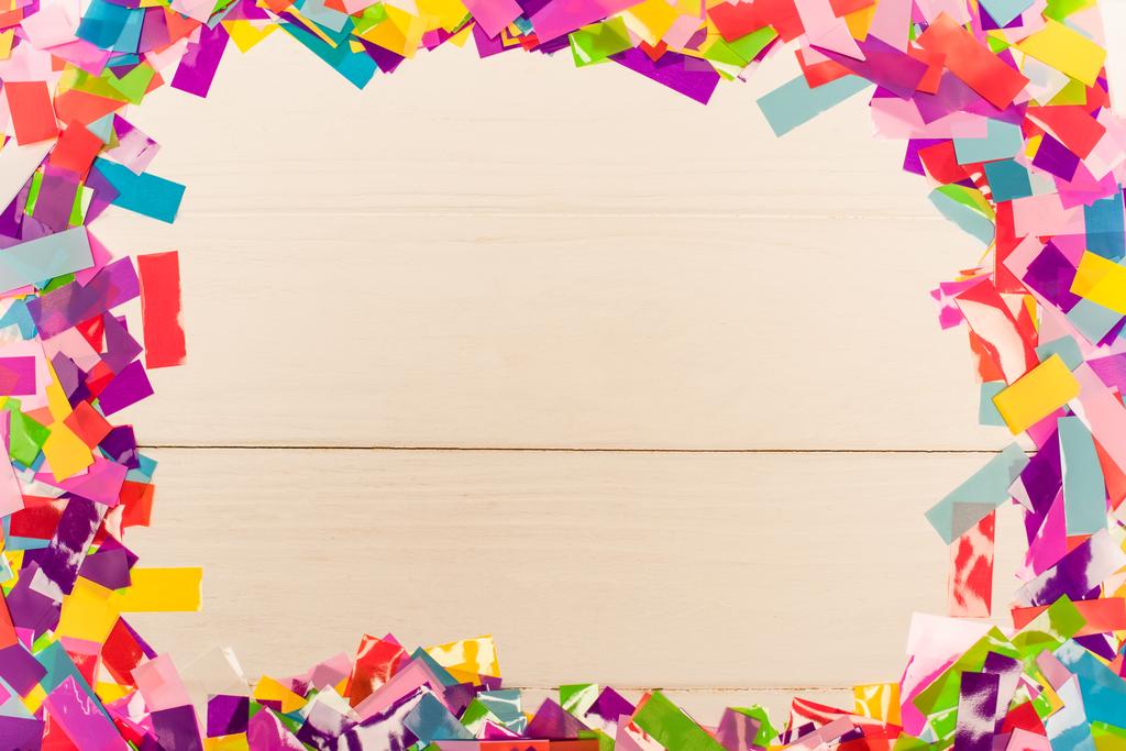 top view of colorful bright confetti frame on wooden background - Photo, Image