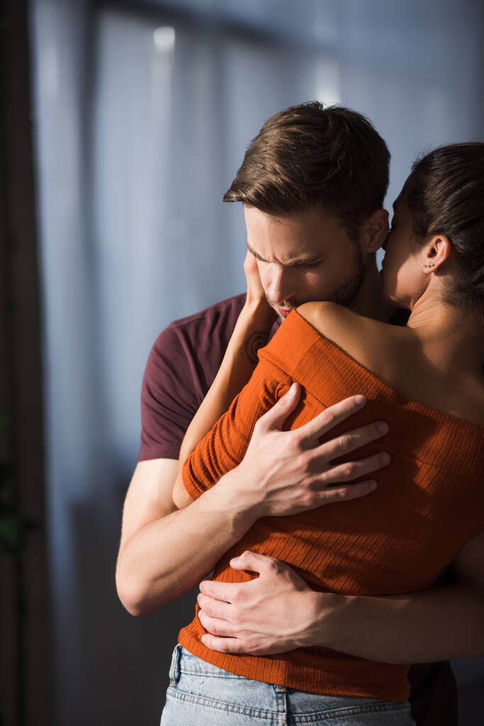 back view of young woman embracing and calming upset boyfriend  - Photo, Image