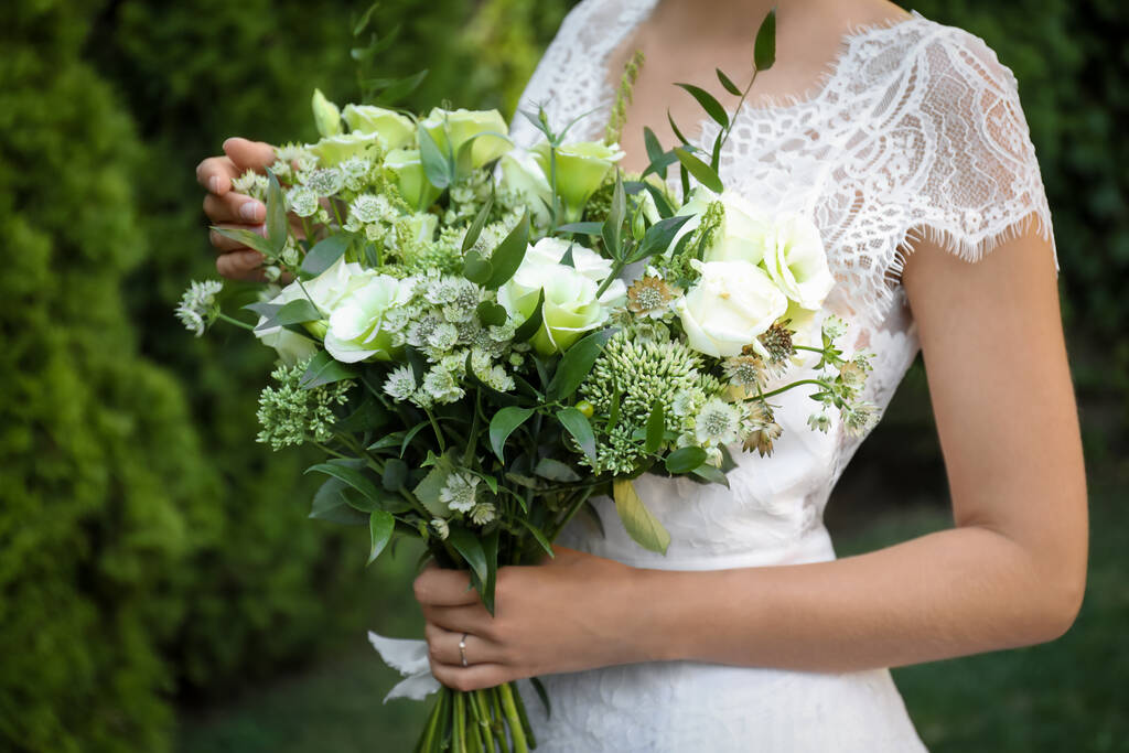 Noiva em belo vestido de noiva com buquê ao ar livre, close-up - Foto, Imagem