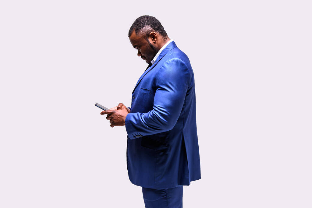 スマートフォンを備えたビジネススーツの男性アフリカ人選手 - 写真・画像