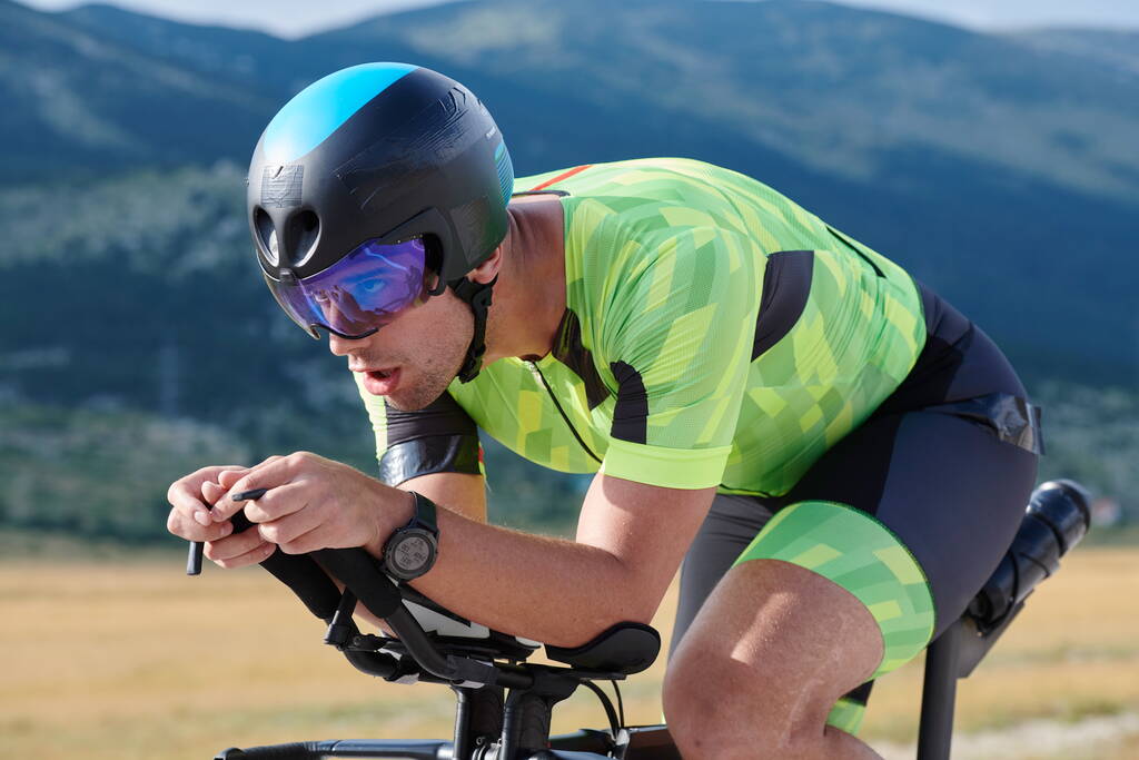 спортсмен тріатлону верхи на професійному гоночному велосипеді на тренуванні на пишній сільській дорозі
 - Фото, зображення
