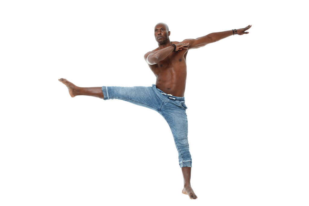 Sportowy młody czarny mężczyzna w dżinsach i z nagim tułowia taniec odizolowany na białym tle. - Zdjęcie, obraz