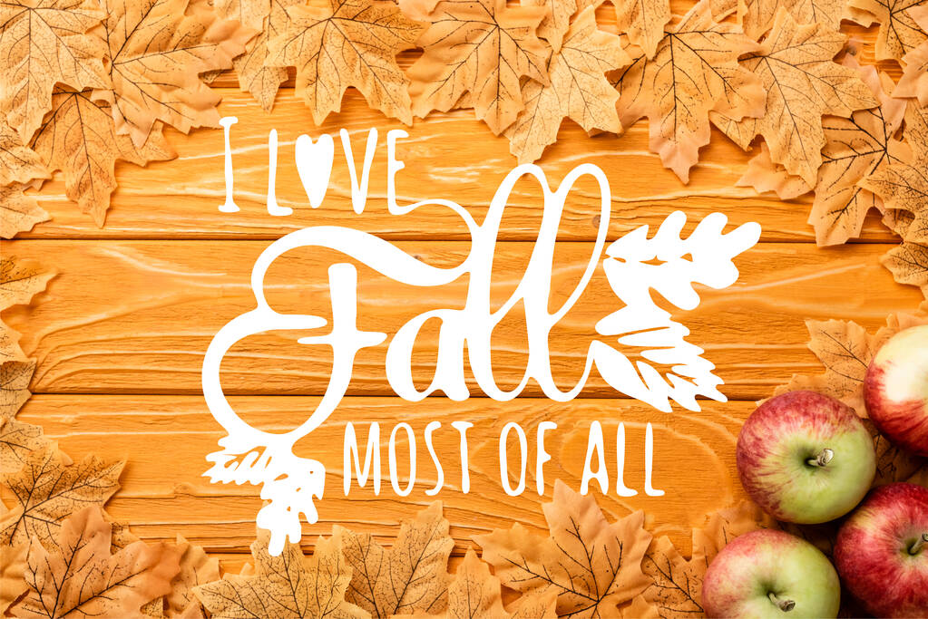 top view of ripe apples and autumnal foliage near i love fall most of all lettering on wooden background - Photo, Image