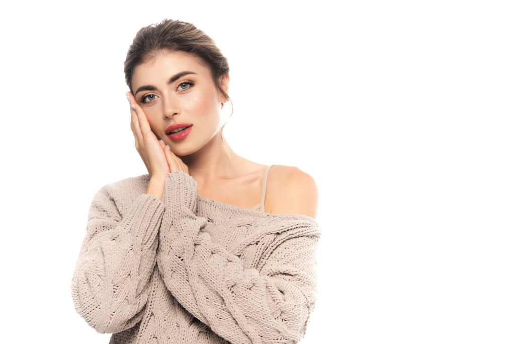 sensual woman in stylish knitted sweater posing with hands near face isolated on white - Photo, Image