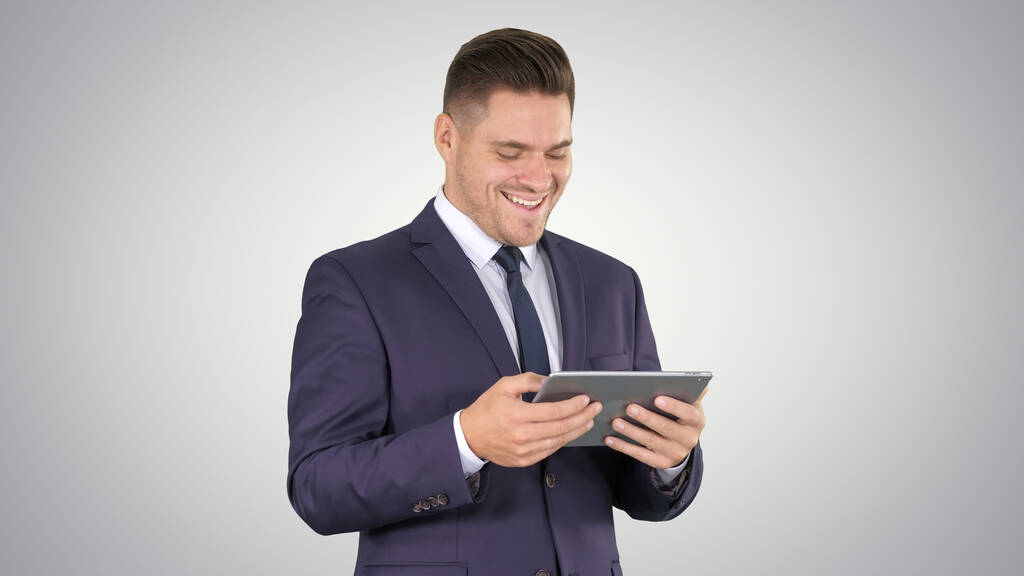 Бізнесмен Читання або робота на цифровому планшеті на градієнті b
 - Фото, зображення