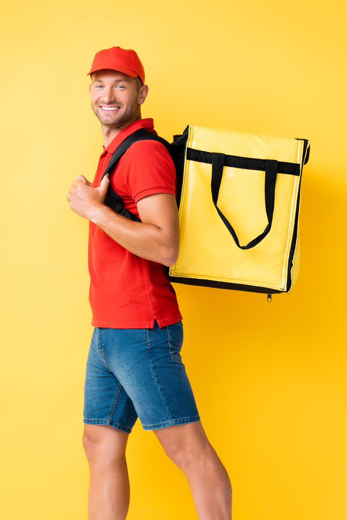 χαρούμενα παράδοση άνθρωπος μεταφέρουν σακίδιο πλάτης με παραγγελία για κίτρινο - Φωτογραφία, εικόνα