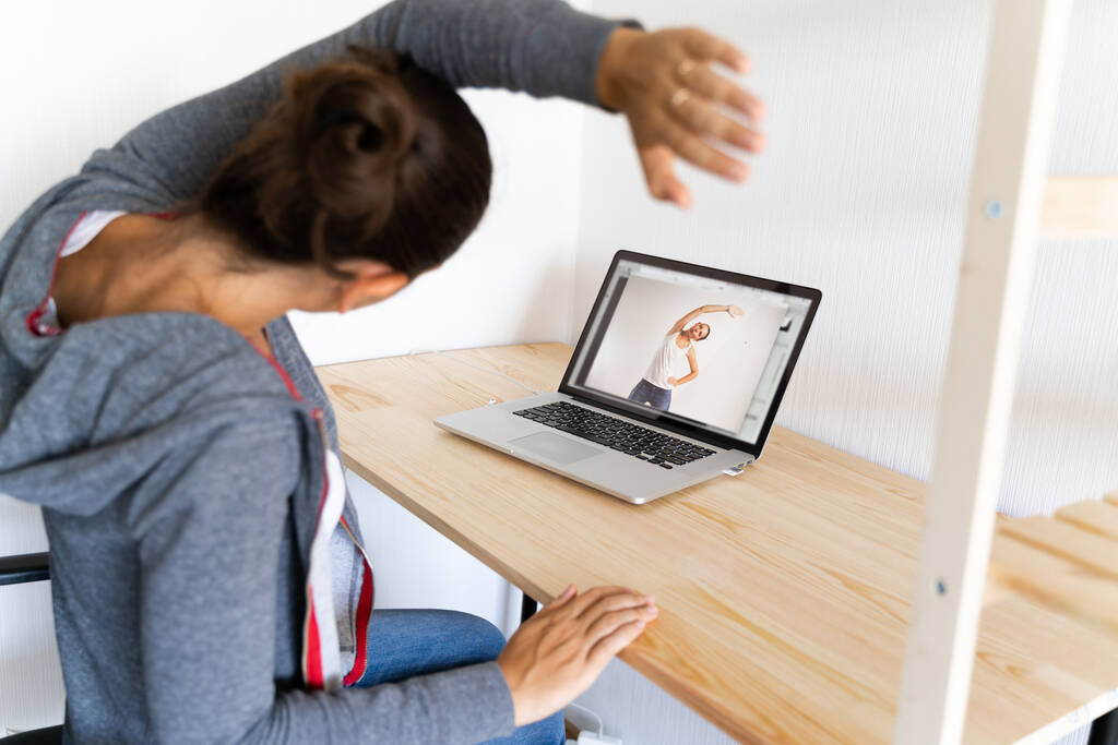 Žena dělá strečink jógu ve své kanceláři podle online sportovního videa. Fitness at work.  - Fotografie, Obrázek