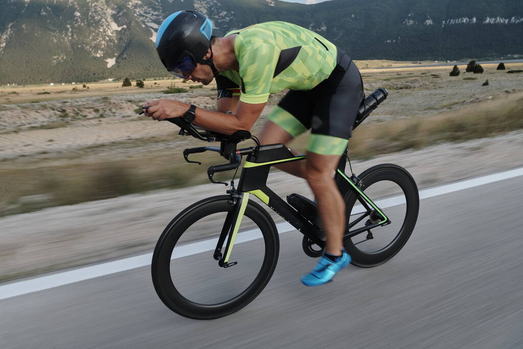 vélo de course professionnel d'athlète de triathlon à l'entraînement sur la route de campagne courbée - Photo, image