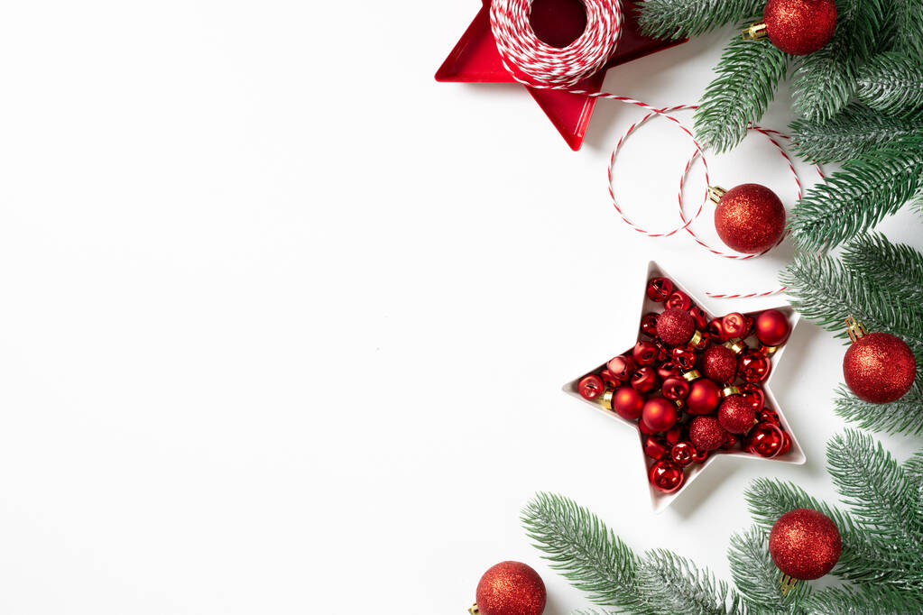 Vánoční pozadí. Červená dekorace na smrkových větvích na bílém pozadí. Vánoce placatě. Pohled shora z kopírovacího prostoru - Fotografie, Obrázek