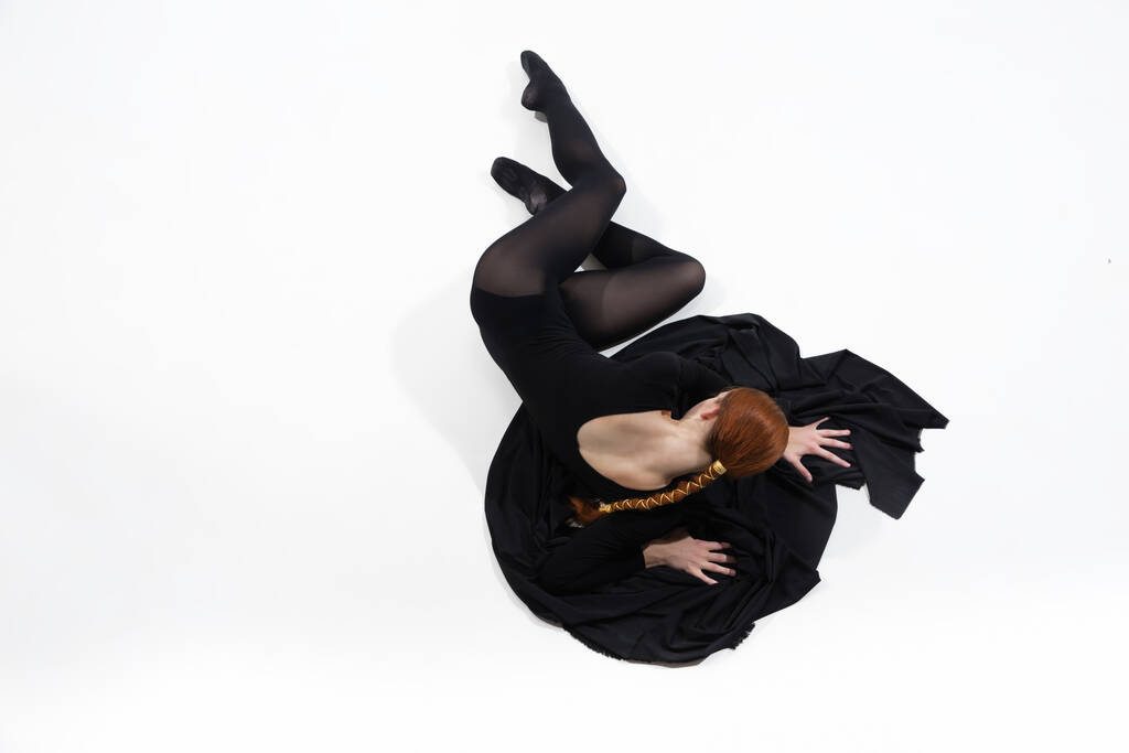 Joven y elegante bailarina de ballet en estilo minimalista negro aislado sobre fondo de estudio blanco - Foto, Imagen