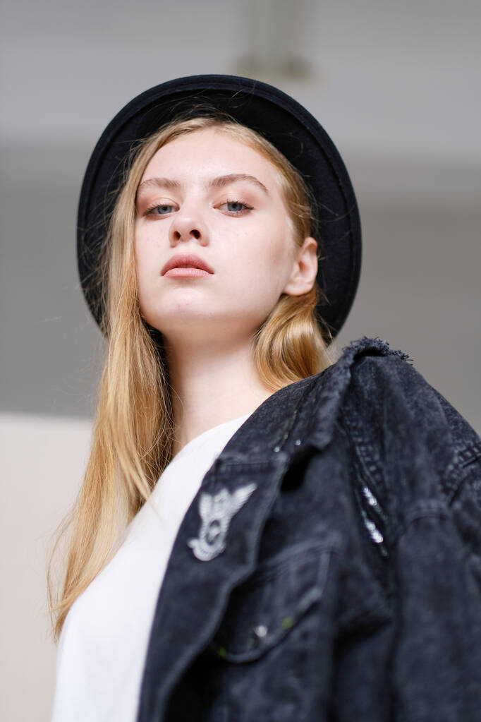 Модная молодая модель в шляпе позирует в студии. Концепция интернет-покупок и онлайн-продаж. - Фото, изображение