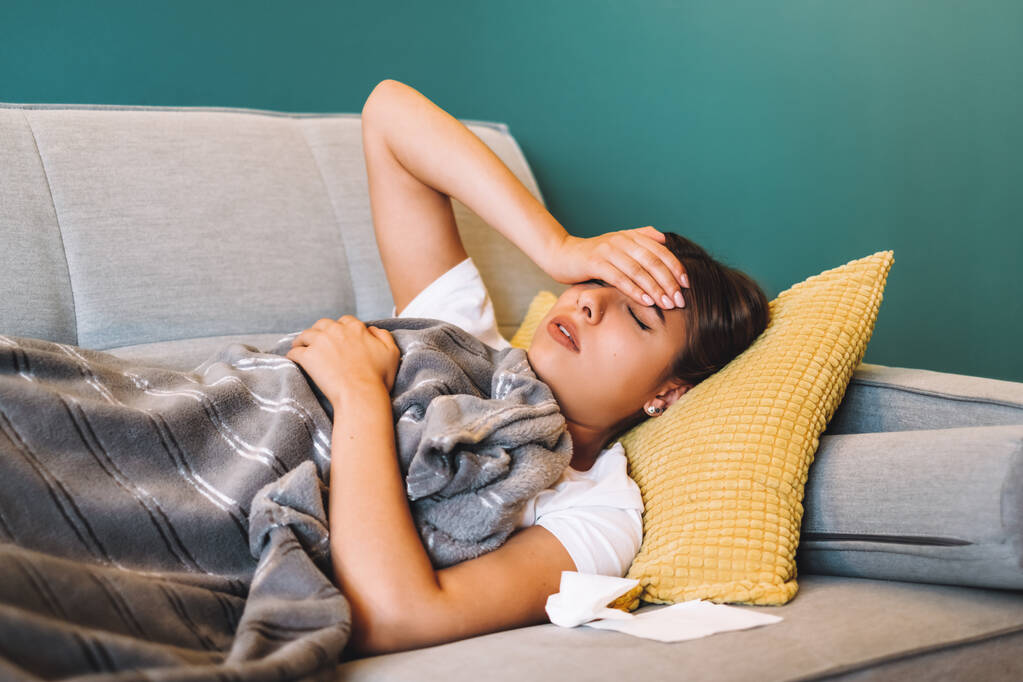 Müde junge Frau berührt Stirn mit Kopfschmerzen Migräne oder Fieber. - Foto, Bild