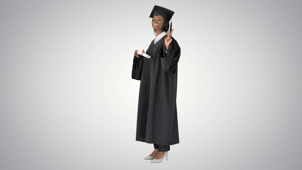 Χαμογελαστή Αφρο-Αμερικανίδα μαθήτρια με στολή αποφοίτησης. - Φωτογραφία, εικόνα