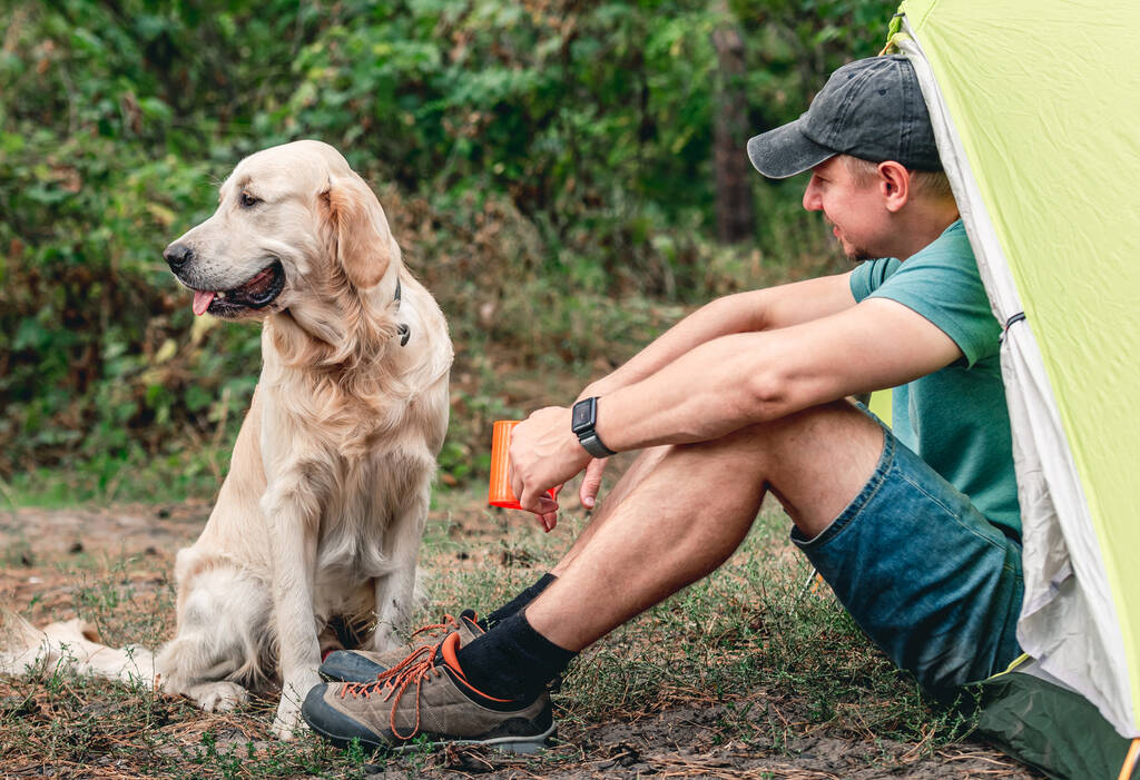 Uomo con cane accanto alla tenda - Foto, immagini
