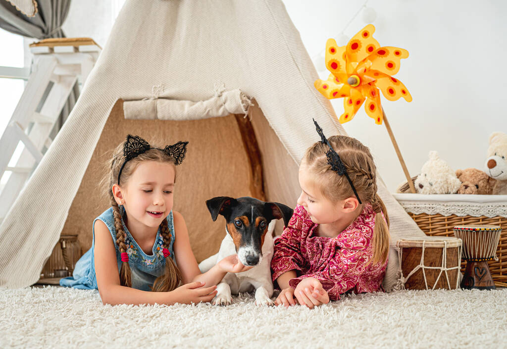 Children lying with dog in wigwam - Photo, Image