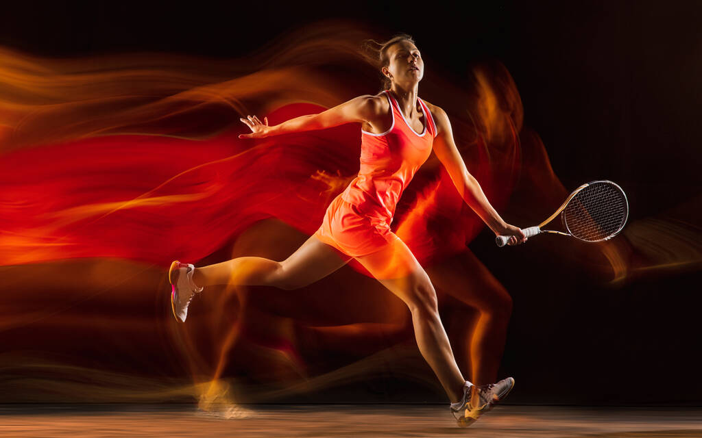 Профессиональная теннисистка на фоне черной студии в смешанном свете - Фото, изображение
