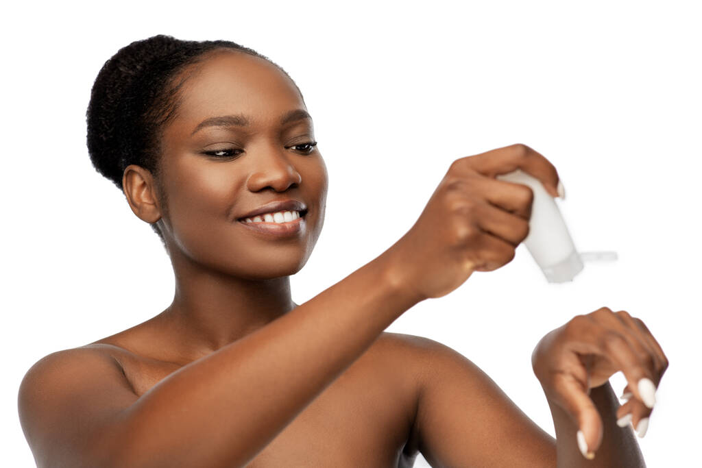 femme afro-américaine souriante avec hydratant - Photo, image