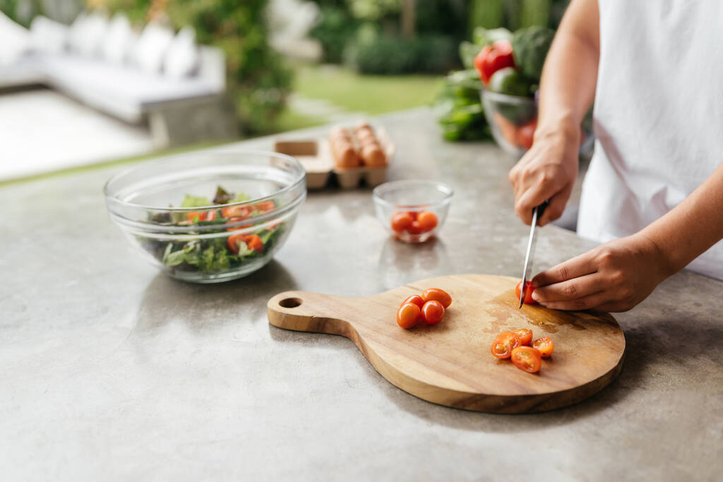 Las manos humanas cocinar verduras ensalada en la cocina - Foto, imagen