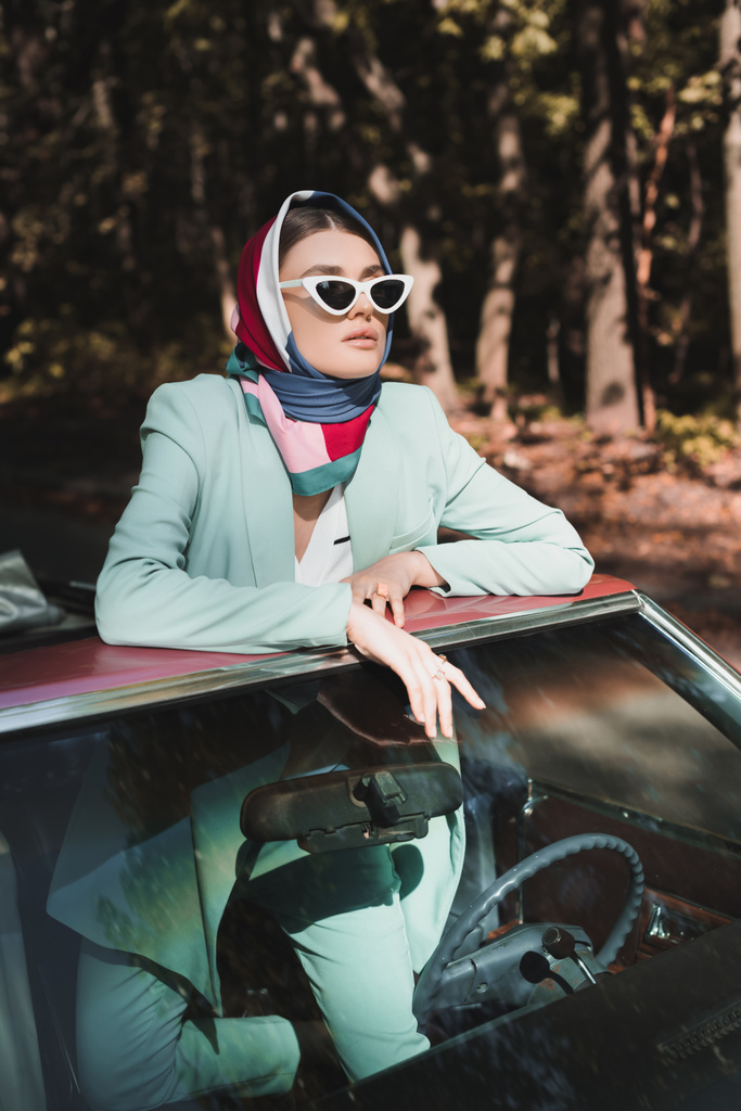 Stylová žena v slunečních brýlích a šátek odvrací pohled od vinobraní střechy auta  - Fotografie, Obrázek