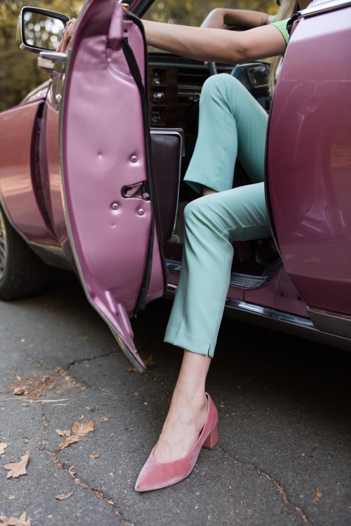 Şık ayakkabılı bir kadının kapıyı açması ve arabadan inmesi. - Fotoğraf, Görsel