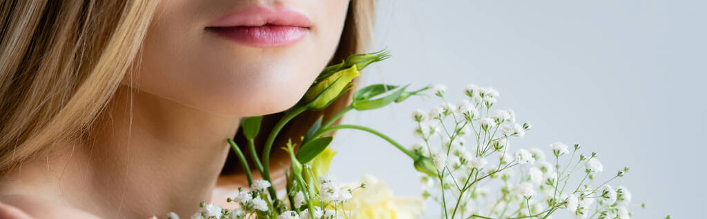 Beyaz, afiş üzerine izole edilmiş çiçeklerin yanındaki genç modelin kırpılmış görüntüsü - Fotoğraf, Görsel