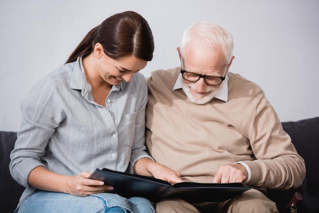 bruna donna con padre anziano guardando album di foto insieme - Foto, immagini