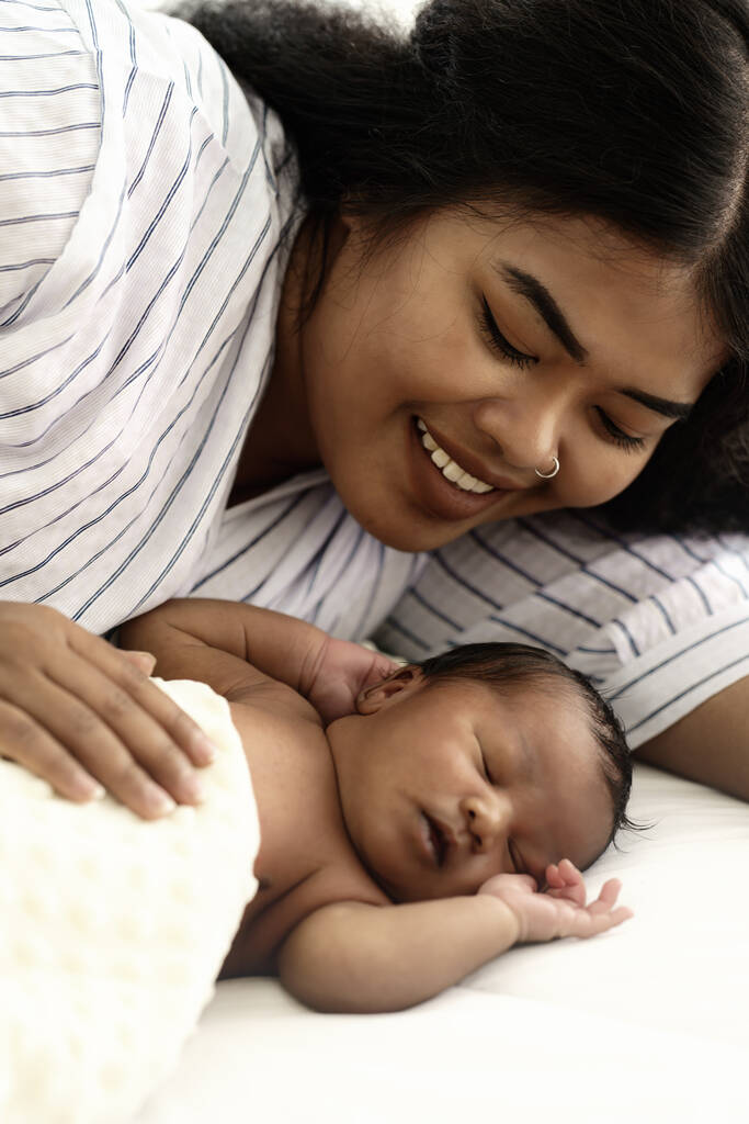 smíšená rasa matka africký americký a asijský lhaní a sledování její novorozenec dítě - Fotografie, Obrázek