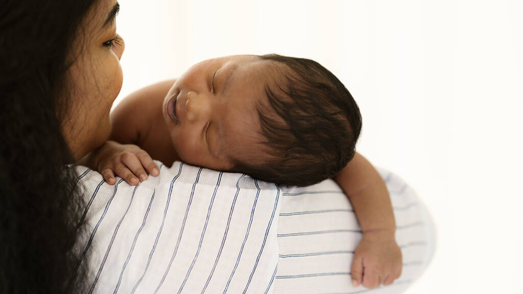 Afrikanisch-amerikanisches Neugeborenes Baby schläft auf Schulter der Mutter - Foto, Bild