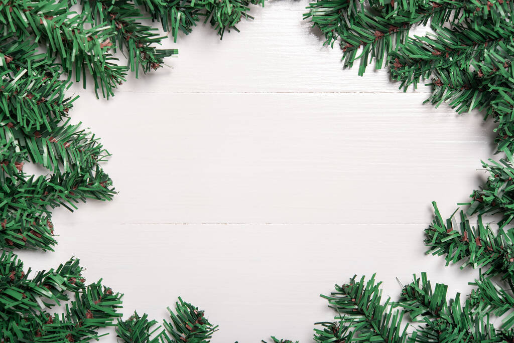 τεχνητό φύλλο χριστουγεννιάτικο δέντρο διακοσμούν σε λευκό ξύλινο φόντο - Φωτογραφία, εικόνα