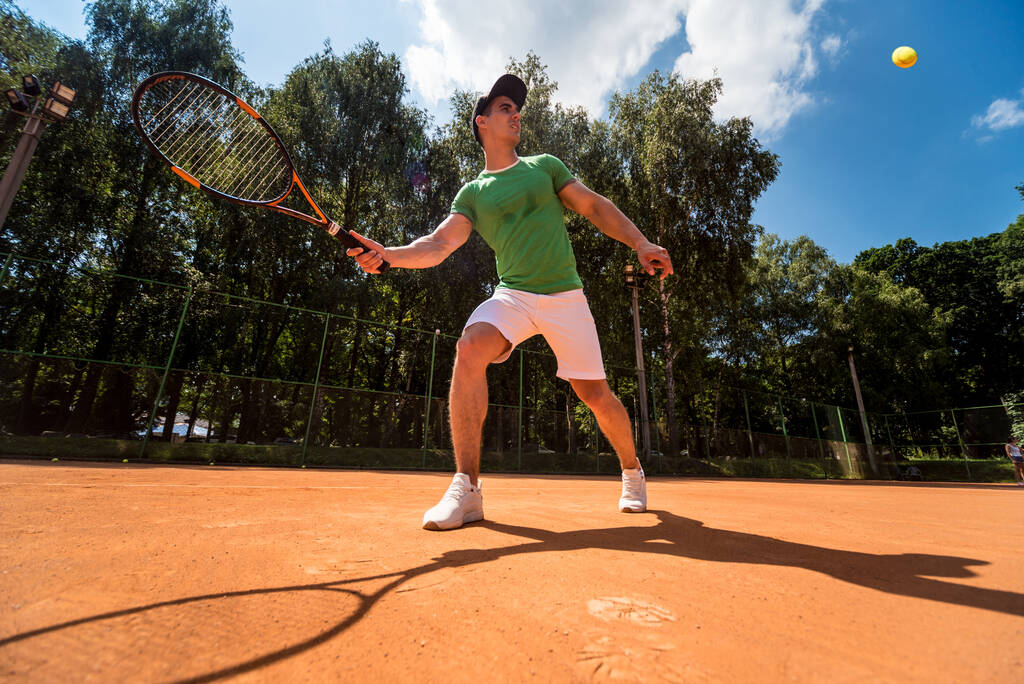 Jovem atlético jogando tênis na quadra. - Foto, Imagem