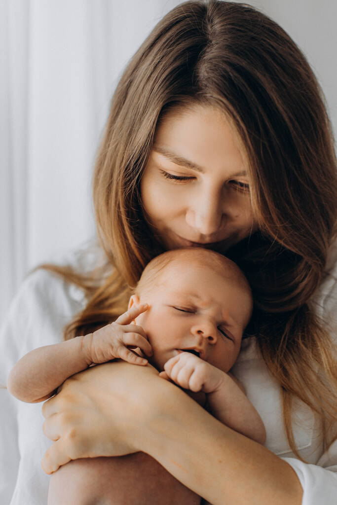 Magnifique femme tenir bébé fille nouveau-né dans les bras, maman heureuse profiter de tendres moments parentaux avec petite fille, concept de maternité - Photo, image
