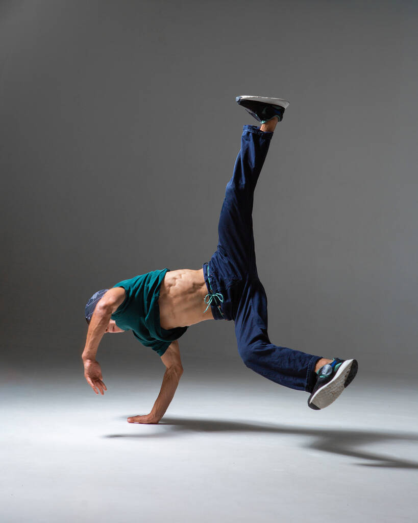 Fajny b-boy taniec w studio odizolowane na szarym tle z miejsca kopiowania. Plakat szkoły breakdance - Zdjęcie, obraz