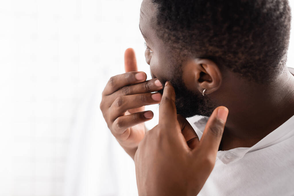 afro-american man trying squeeze pimple - Photo, Image