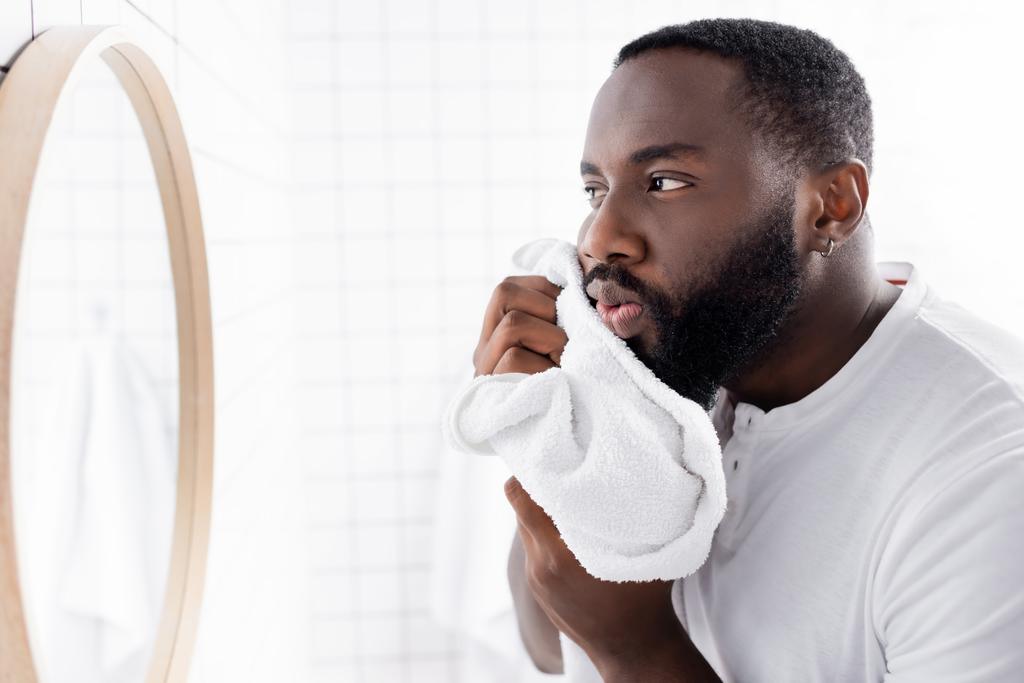 uomo afro-americano asciugatura barba con asciugamano  - Foto, immagini
