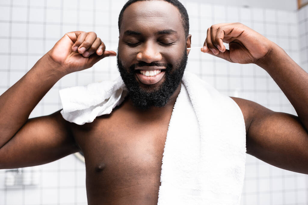 retrato de hombre afro-americano limpiando orejas con placer - Foto, imagen