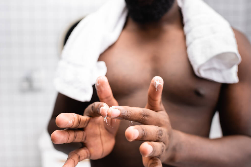 wybiórcze skupienie się na człowieku afro-amerykańskim stosującym lekarstwo na wzmocnienie wzrostu brody - Zdjęcie, obraz