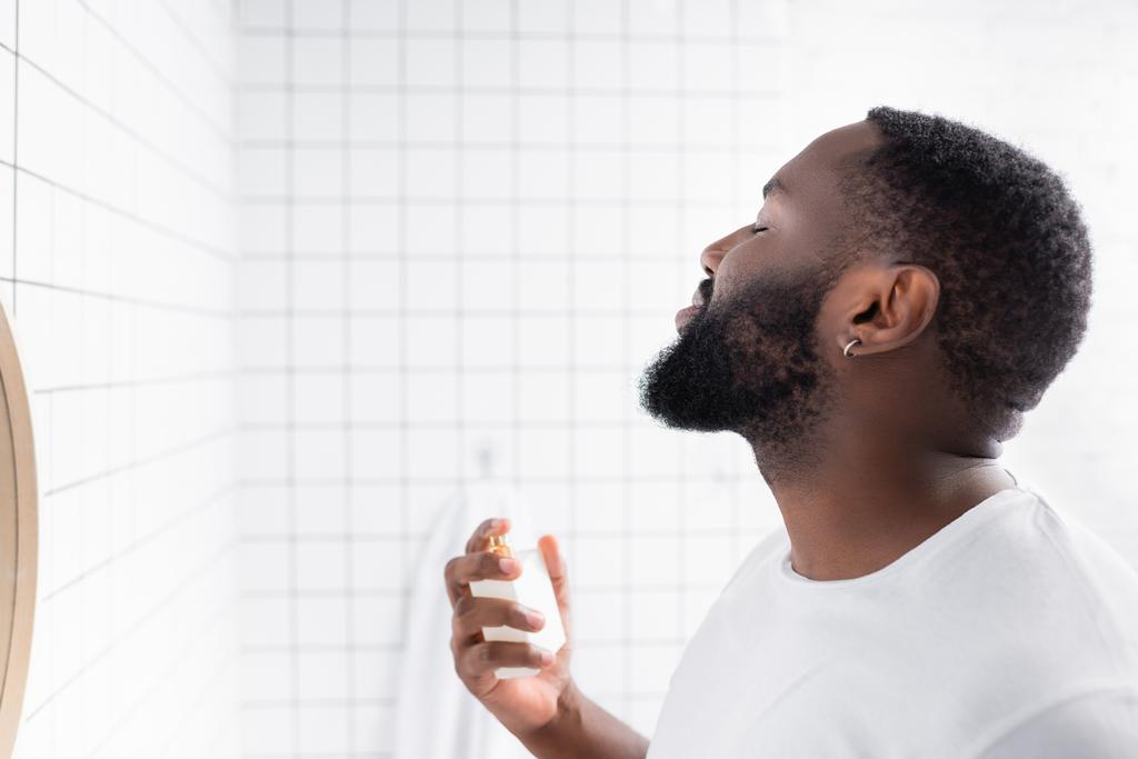 homem afro-americano em t-shirt branca usando perfume  - Foto, Imagem