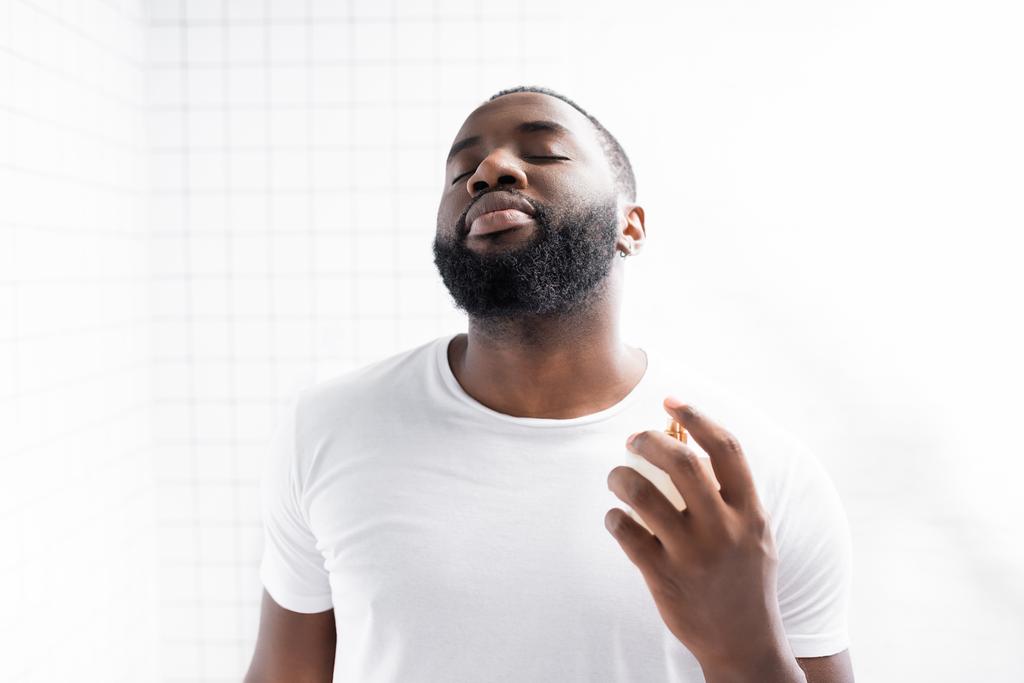 retrato de homem afro-americano em t-shirt branca usando perfume - Foto, Imagem