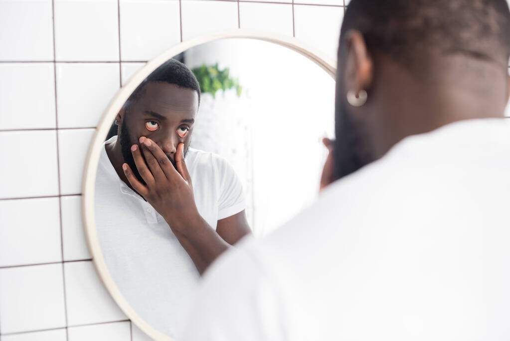 tired afro-american man pulling lower eyelids with fingers - Photo, Image