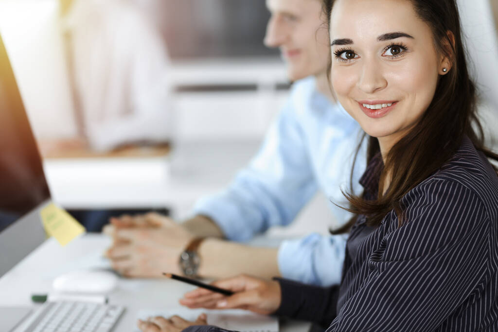 Επιχειρηματίας γυναίκα και ο άνθρωπος συζητά θέματα, ενώ η χρήση του υπολογιστή στο χώρο εργασίας σε ηλιόλουστο γραφείο - Φωτογραφία, εικόνα