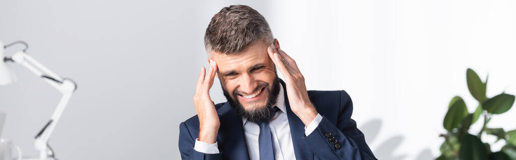 Бизнесмен в формальной одежде страдает от головной боли в офисе, баннер  - Фото, изображение