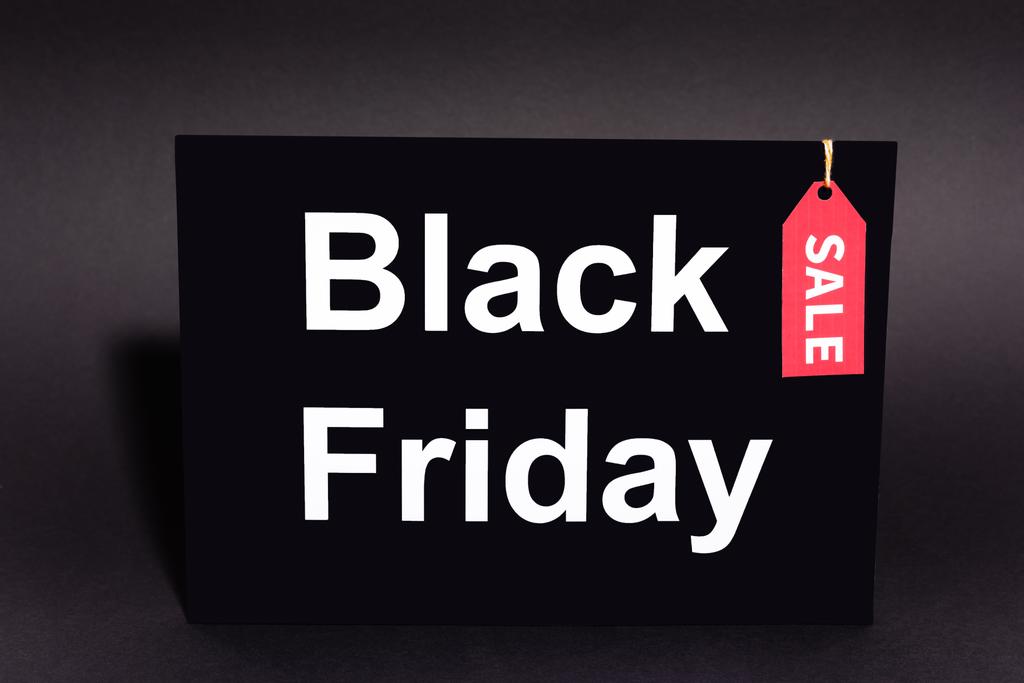 cartel con letras de viernes negro y etiqueta de venta sobre fondo oscuro - Foto, Imagen