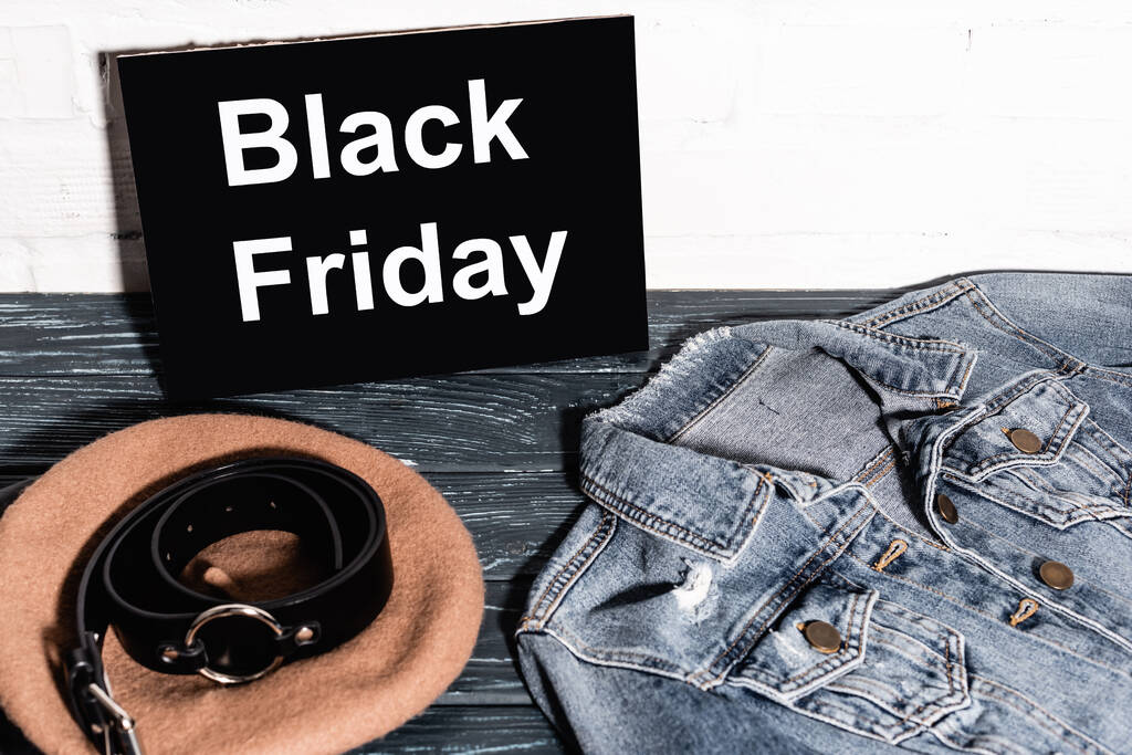 denim jacket near placard with black friday lettering, beret and belt  - Photo, Image