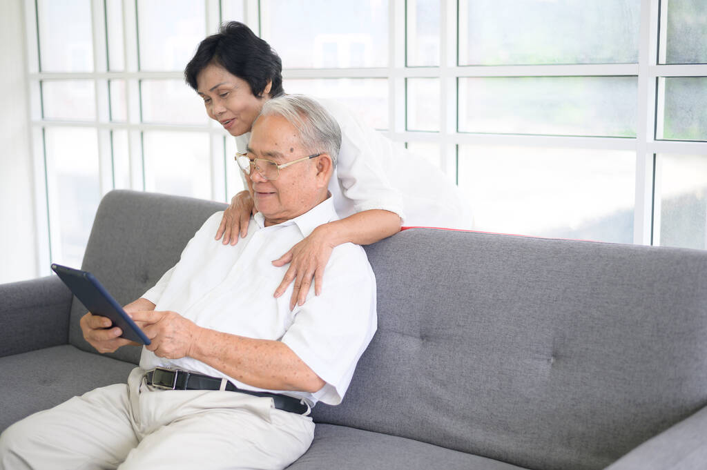Šťastný starší asijský pár používá tablet a mluví s rodinou na webkameru doma, koncept odchodu do důchodu. - Fotografie, Obrázek