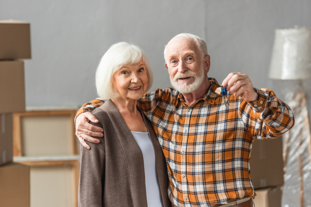 starší muž objímající ženu a držící klíče, pohybující se koncept - Fotografie, Obrázek